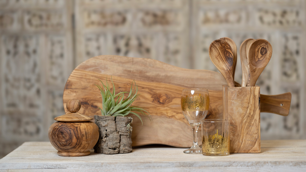 Beautiful natural olive wood cheese board paired with olive wood spoons. Gold abstract wineglass and double old fashioned glassware.